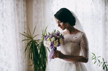 Bir buket onun elinde tutan güzel gelin esmer