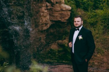 Bir takım elbise ve papyon bir yürüyüş için damat