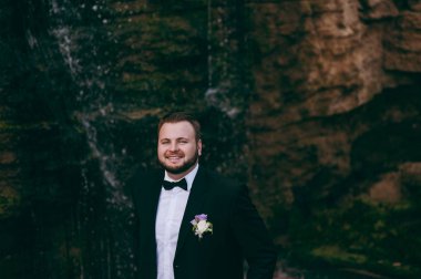 Bir takım elbise ve papyon bir yürüyüş için damat