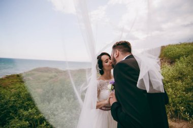 Damat ve gelin açık havada suya yakın bir yolda