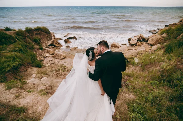 Γαμπρός και νύφη σε έναν περίπατο σε εξωτερικούς χώρους κοντά στο νερό — Φωτογραφία Αρχείου