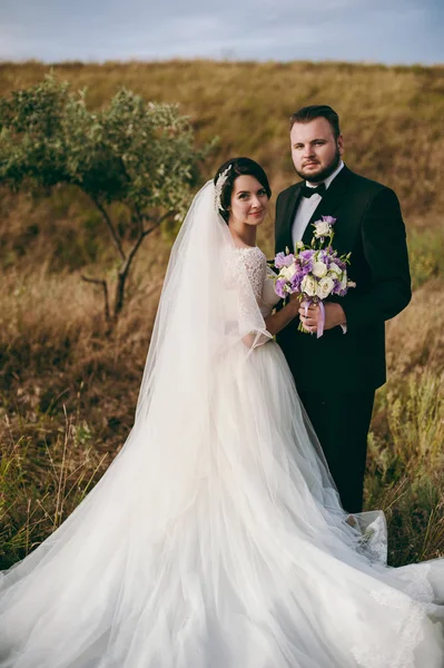 Brudgummen och bruden på en promenad utomhus — Stockfoto