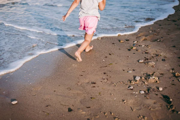 Маленькая девочка бежит по морскому пляжу — стоковое фото