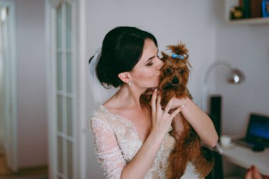 Düğün gününde güzel bir gelin portresi. Gelin köpek öpüyor.