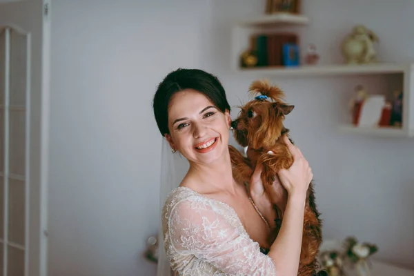 Porträt einer schönen Braut am Hochzeitstag. die Braut küsst den Hund. — Stockfoto