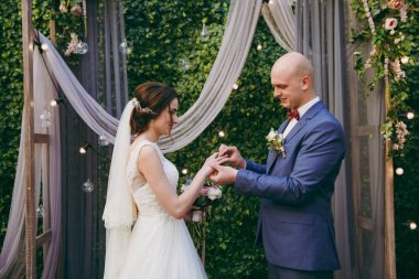 Gelin ve damat yüzükleri deniz kenarında bir törende giyiyorsun