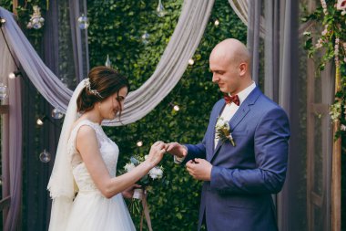 Gelin ve damat yüzükleri deniz kenarında bir törende giyiyorsun