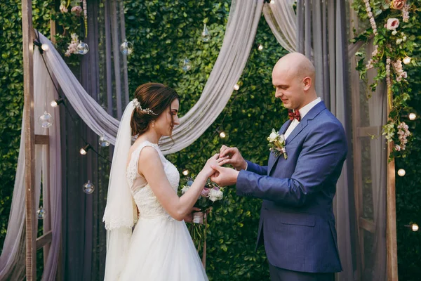 Gelin ve damat yüzükleri deniz kenarında bir törende giyiyorsun