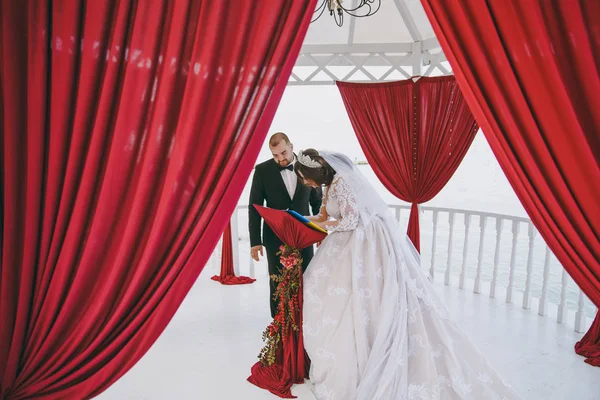 Braut und Bräutigam setzen ihre Unterschrift unter die Zeremonie — Stockfoto