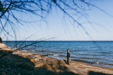 Bir takım elbise ve kravat denizde bir yürüyüşe damat