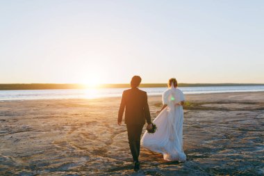 Damat ve gelin açık havada denizde bir yolda