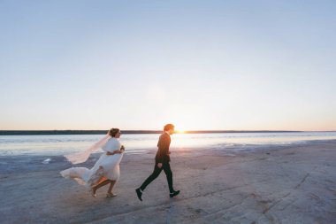 Damat ve gelin açık havada denizde bir yolda