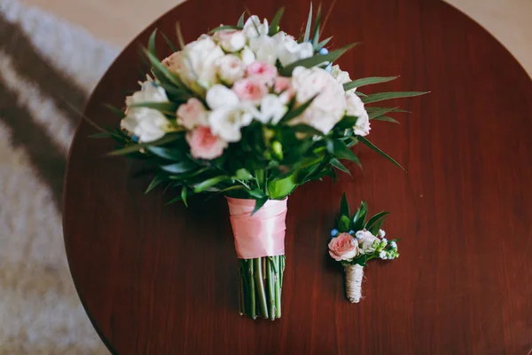 Belo buquê de flores da noiva e boutonniere mentira sobre a mesa — Fotografia de Stock