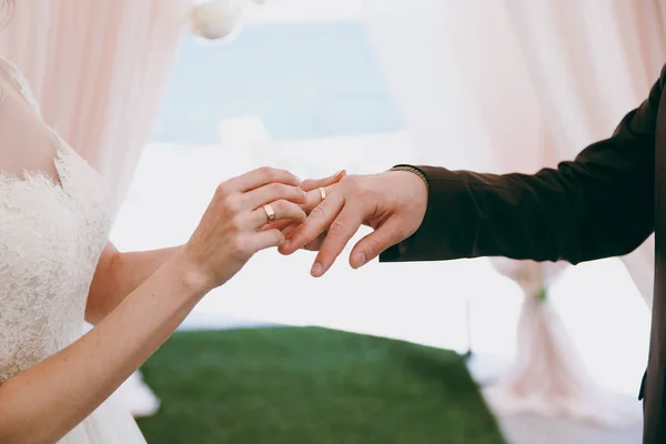 Bride and groom put rings on each other and show them at the ceremony — Stock Photo, Image