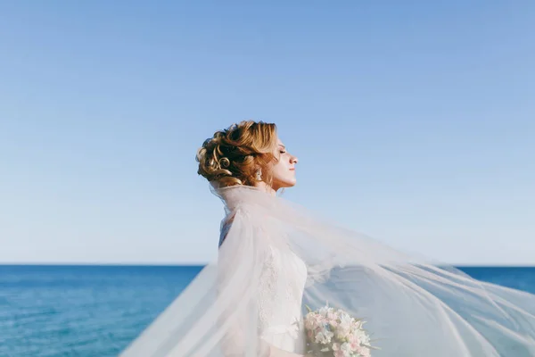 Όμορφη ξανθιά νύφη σε έναν περίπατο δίπλα στη θάλασσα — Φωτογραφία Αρχείου