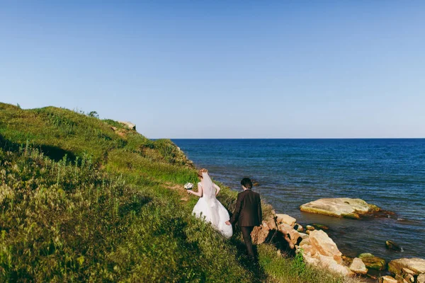 Γαμπρός και νύφη σε έναν περίπατο σε εξωτερικούς χώρους στη θάλασσα — Φωτογραφία Αρχείου