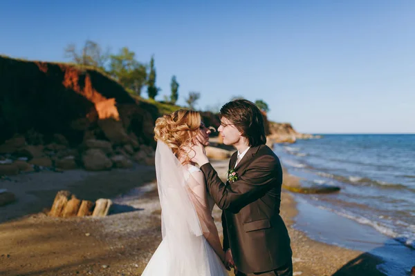 Sposo e sposa in una passeggiata all'aperto al mare — Foto Stock