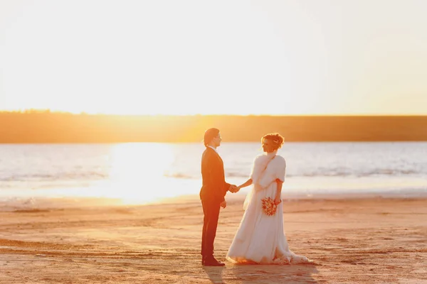 Bräutigam und Braut beim Spaziergang im Freien am Meer — Stockfoto