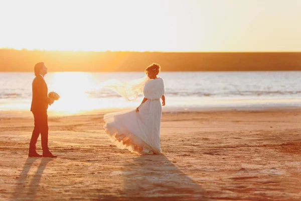 Bräutigam und Braut beim Spaziergang im Freien am Meer — Stockfoto