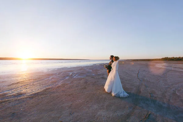 Sposo e sposa in una passeggiata all'aperto al mare — Foto Stock