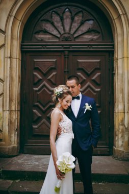 Bir düğün çifti bir binanın merdivenlerinde duruyor