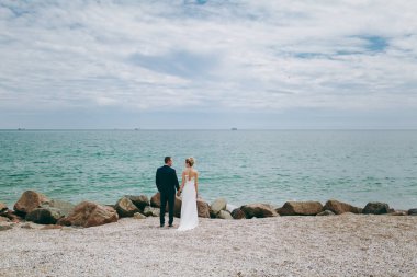 Damat ve gelin açık havada denizde bir yolda