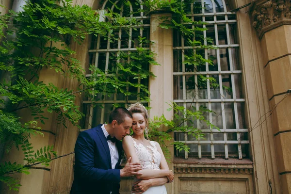 Um casal de casamentos está nos degraus de um edifício — Fotografia de Stock