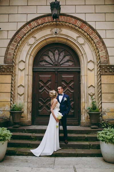 Um casal de casamentos está nos degraus de um edifício — Fotografia de Stock