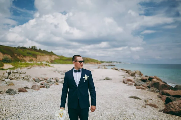 Groom in a suit and a tie for a walk at the sea — Stock Photo, Image