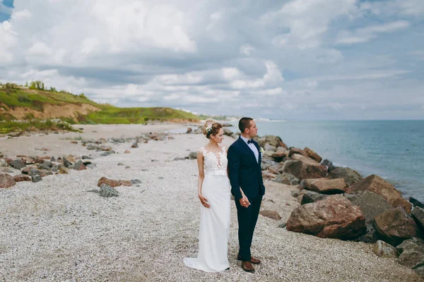 Brudgummen och bruden på en promenad utomhus vid havet — Stockfoto