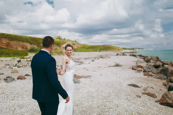 Brudgummen och bruden på en promenad utomhus vid havet — Stockfoto