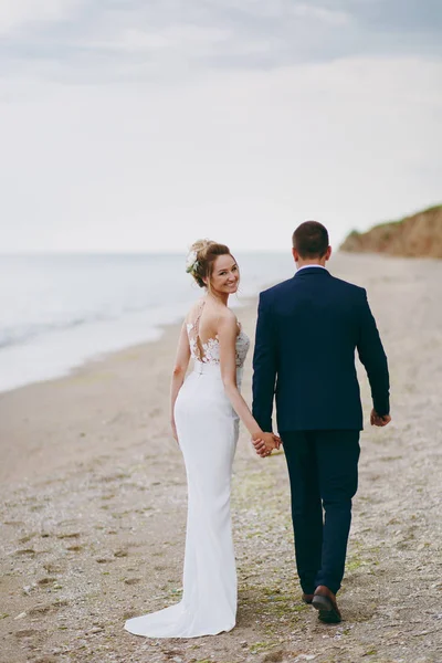 Bräutigam und Braut beim Spaziergang im Freien am Meer — Stockfoto
