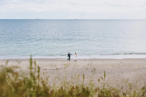 Groom and bride on a walk outdoors at the sea — Stock Photo, Image