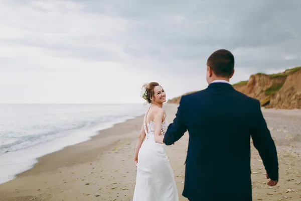 Groom and bride on a walk outdoors at the sea — Stock Photo, Image