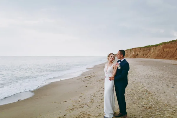 Groom and bride on a walk outdoors at the sea — Stock Photo, Image