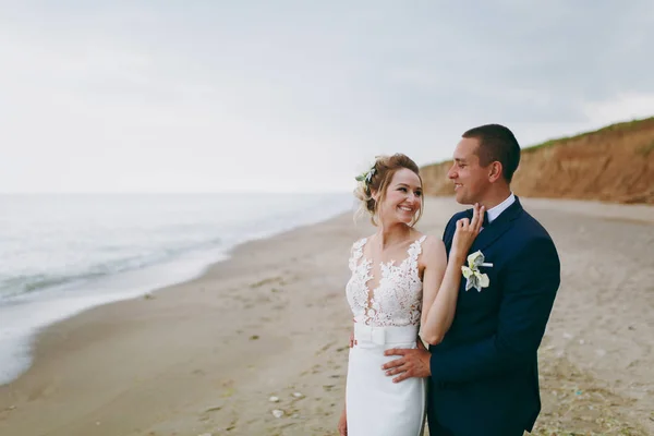 Bräutigam und Braut beim Spaziergang im Freien am Meer — Stockfoto