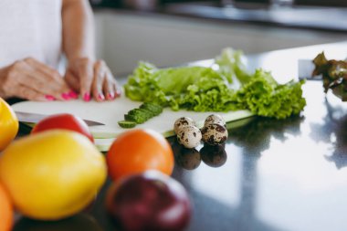 Genç kadın mutfakta yemek. Sağlıklı gıda - sebze salatası. Bıldırcın yumurtası. Diyet kavramı. Sağlıklı bir yaşam tarzı. Evde yemek. Yemek hazırlamak kadar yakın