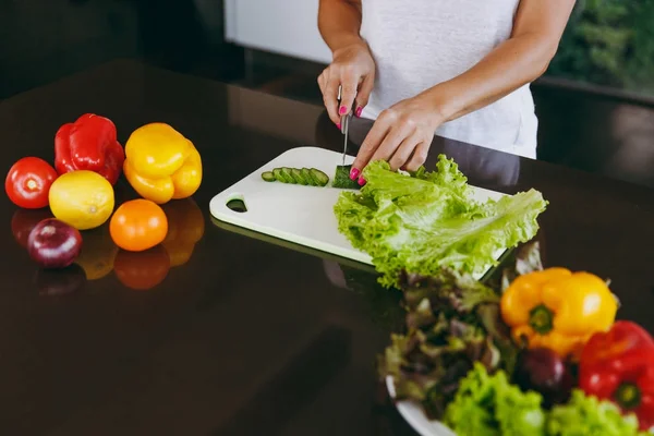Молодая женщина режет овощи на кухне ножом. Здоровое питание - овощной салат. Концепция диеты. Здоровый образ жизни. Готовить дома. Приготовьте еду. — стоковое фото
