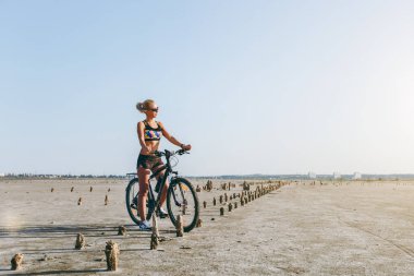 Çok renkli bir takım elbise ve güneş gözlüğü güçlü bir sarışın kadın oturur