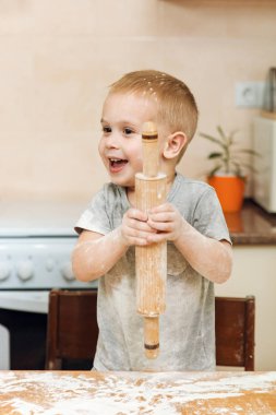 Küçük çocuk çocuk anne Noel zencefilli bisküvi pişirmek için yardımcı olur. 
