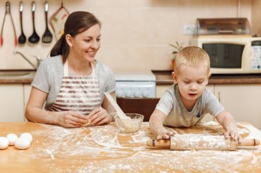 Küçük çocuk çocuk anne Noel masanın üzerine tablet ile ışık mutfakta zencefilli bisküvi pişirmek için yardımcı olur. Mutlu aile anne 30-35 yıl ve çocuk 2-3 hafta sonu sabah evde. İlişki kavramı