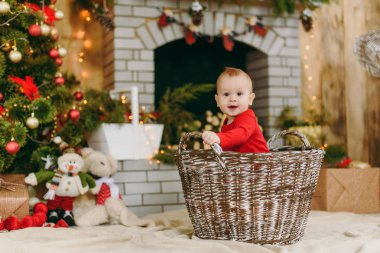 Sepet içinde bir şekilde dekore edilmiş Oda evde oturan oynak mutlu sevimli küçük oğlu, portresi. Noel keyfi. Yeni yıl. Yaşam tarzı, Aile ve beraberlik kavramı.