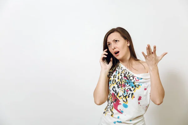 Wütende braunhaarige Frau, die auf einem Mobiltelefon auf weißem Hintergrund spricht. Emotionen-Konzept. — Stockfoto