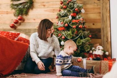 Genç neşeli mutlu anne ile dekore edilmiş yeni yıl Oda Noel ağacı, Noel Baba ile evde oturan hoş küçük çocuk çocuk portresi. İyi bir ruh hali. Yaşam tarzı, Aile ve tatil 2018 kavramı