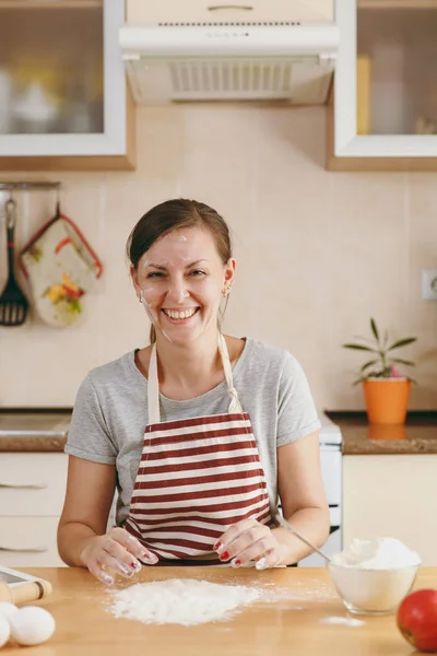 Una mujer alegre divertida joven sentada en una mesa con harina e ir a preparar un pastel de Navidad en la cocina. Cocinar en casa. Preparar alimentos . —  Fotos de Stock