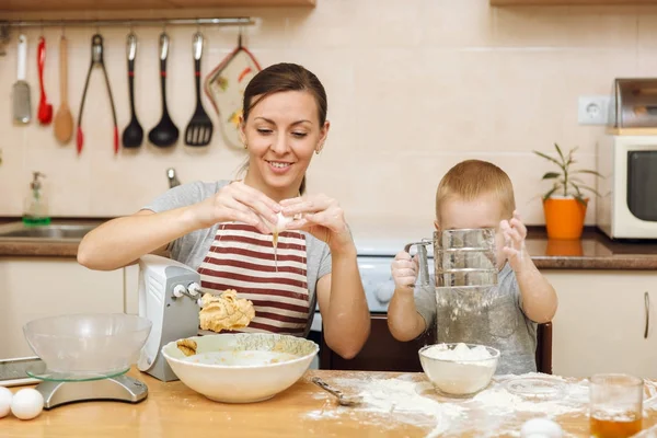 Jongen-jongetje helpt moeder om te koken kerst gember koekje in lichte keuken met tablet op tafel. Gelukkige familie moeder 30-35 jaar en kind 2-3 in weekend's ochtends thuis. Begrip van de relatie — Stockfoto