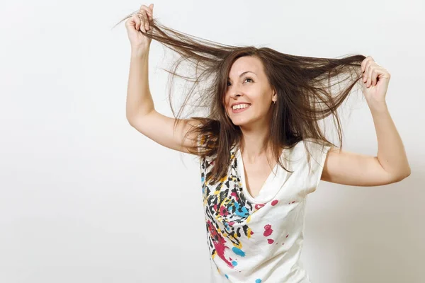 Beautiful European young funny and cheerful brown-haired woman with healthy clean skin, dressed in casual light clothes is fooling around at camera, on a white background. Emotions concept. Stock Picture