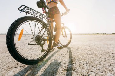 Bir çöl olan bir bisiklet çok renkli elbiseli bir kadın oturur