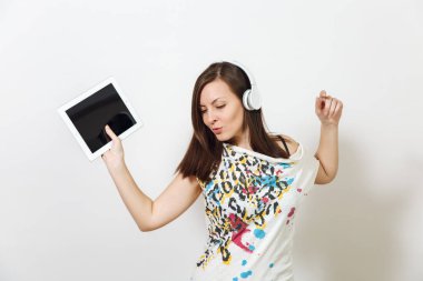 Güzel duygusal Avrupa kahverengi saçlı bir kadınla sağlıklı temiz cilt, büyüleyici smile, rahat hafif kıyafetler giymiş, dinler ve beyaz zemin üzerine tablet ile kulaklıklar müzik hoşlanır.