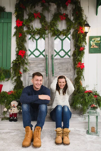 Happy funny young couple in love dressed in sweater sitting on p — Stock Photo, Image